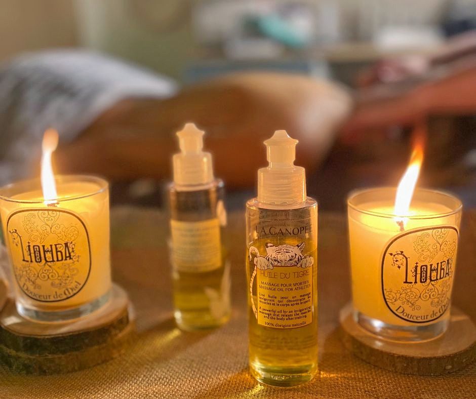 Deux bougies allumées près des huiles de massage