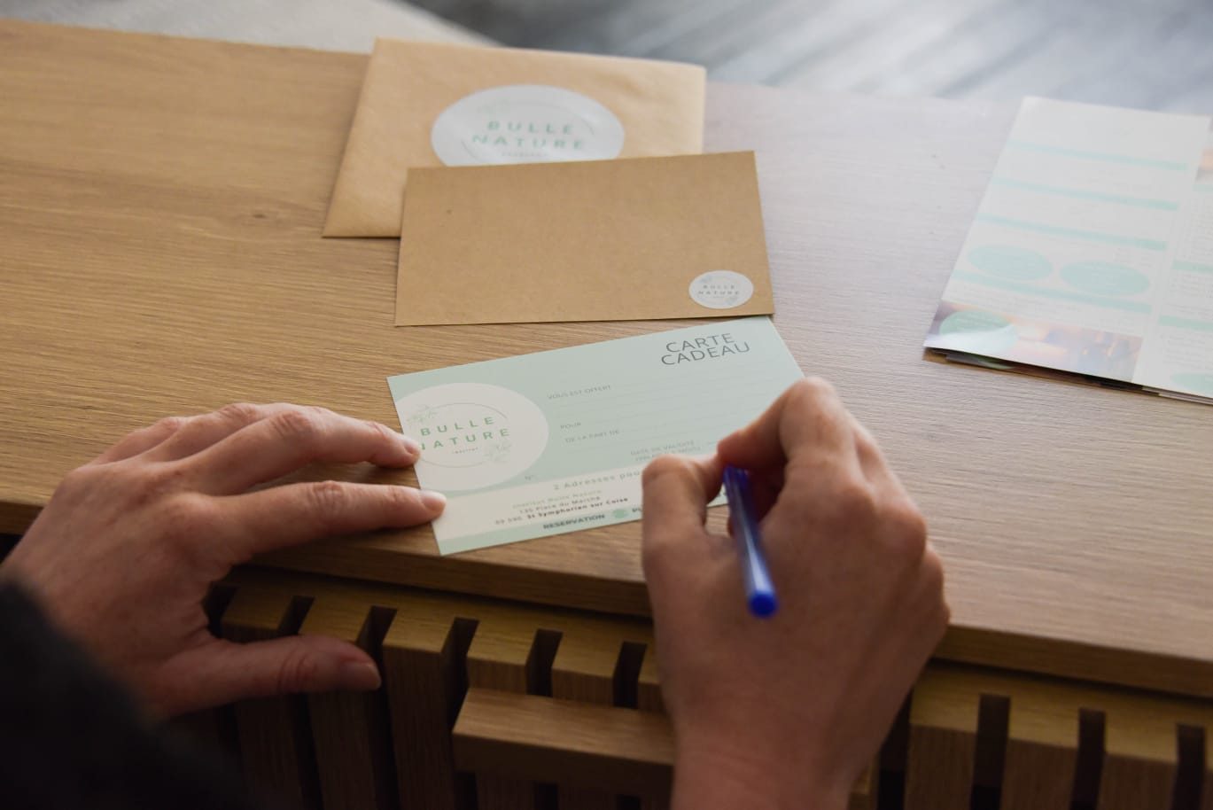 Une carte cadeau Bulle Nature tenue entre deux mains