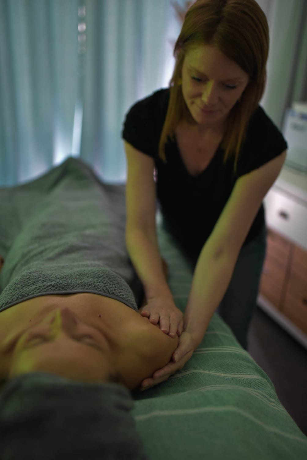 Un massage du dos dans la lumière verte de la cabine